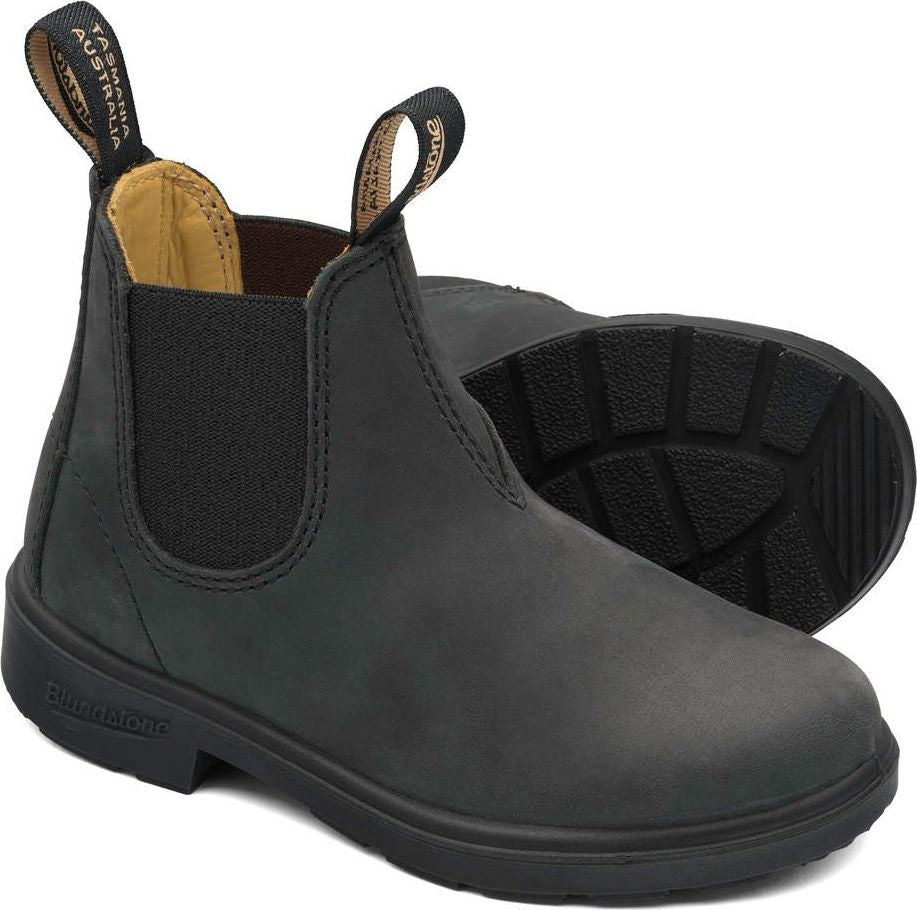Two matte black, ankle high, Chelsea boots are side by side and slightly overlap, showing elastic side panel and lug soles.