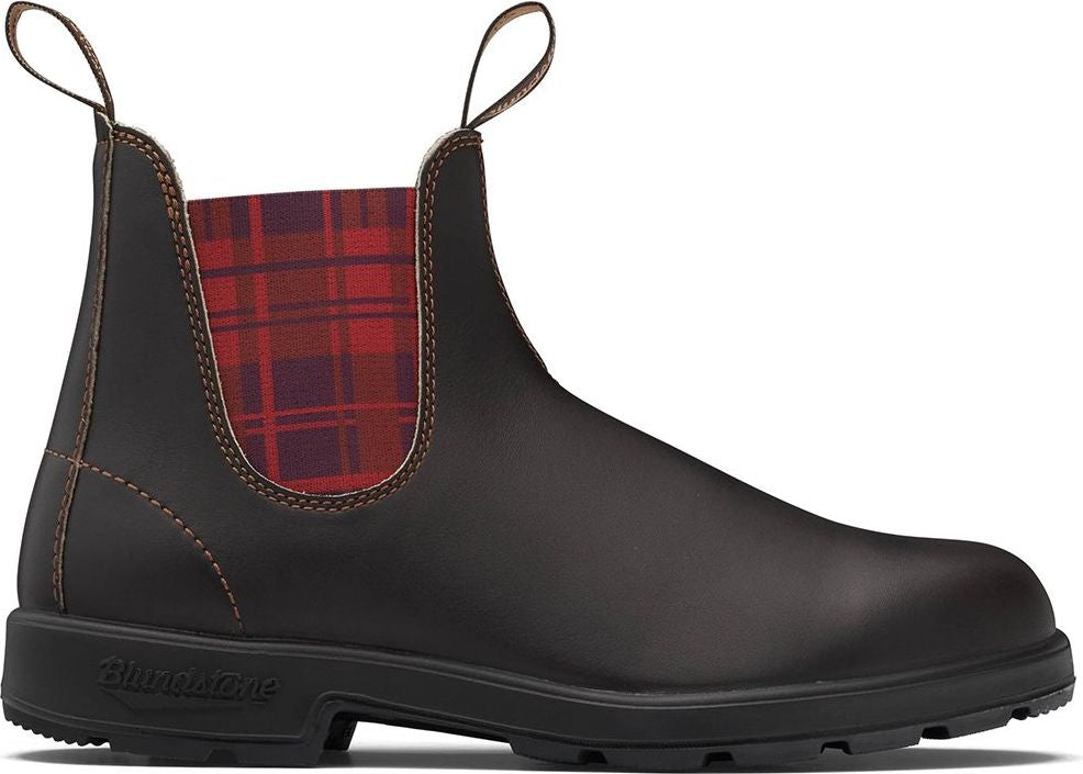 A brown leather chelsea boot with a black sole and plaid elastic side panel.