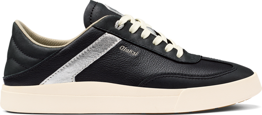 A black sneaker with white laces and a thick white sole.