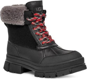 Black UGG boot with a gray faux fur trim, red patterned laces, and a lug sole.