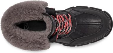 A high-angle shot of a black boot with red and white laces and a grey fur lining.