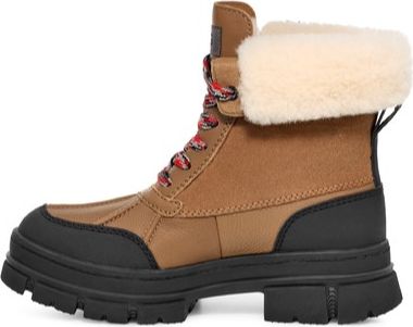 Tan ankle boot with black sole and off-white furry collar, laced up with red and black laces.