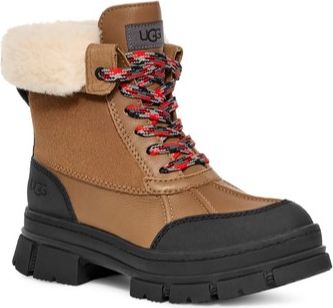 Tan ankle boot with black soles and faux fur collar, with red, black, and white patterned shoelaces.