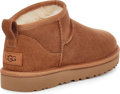 Brown ankle boot with suede-like texture, low profile sole and a pull loop on the heel with the letters "UGG".