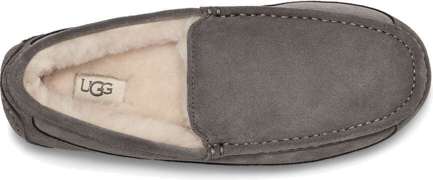 Gray suede loafer-style slipper with visible fluffy lining and a UGG tag inside.