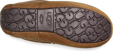 Brown moccasin slipper with a black textured sole with the UGG logo.