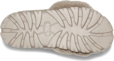 Tan slipper sole with deeply etched wavy treads and UGG logo visible in the center.