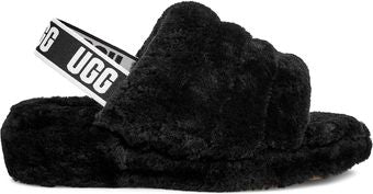 Black furry slide with a white and black strap that says UGG in large letters.
