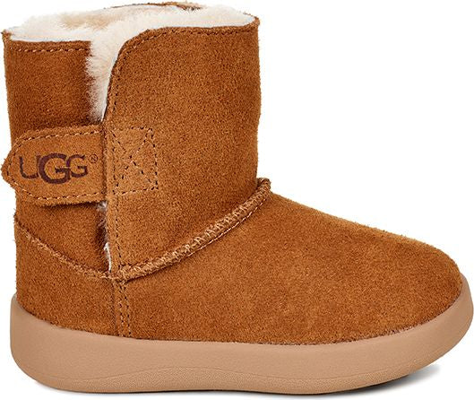 Tan suede toddler boot with light colored fleece lining and Velcro strap with "UGG" logo.