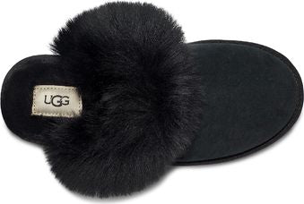 Black slipper with fur pom and a UGG brand tag.
