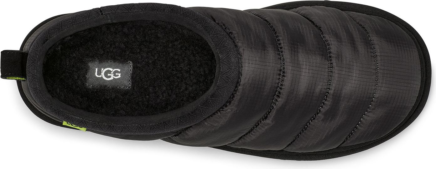 A top down shot of a black slipper with the UGG logo on the insole.